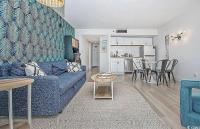 ein Wohnzimmer mit einer blauen Couch und einem Tisch in der Unterkunft Coastal Comfort Your Perfect Beachfront Getaway in Myrtle Beach