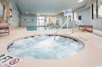 eine Whirlpool-Badewanne mitten im Pool in der Unterkunft Coastal Comfort Your Perfect Beachfront Getaway in Myrtle Beach