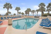 einen Pool mit blauen Stühlen und Palmen in der Unterkunft Coastal Comfort Your Perfect Beachfront Getaway in Myrtle Beach
