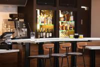 a bar with four chairs and a counter with bottles of alcohol at Courtyard by Marriott Knoxville Airport Alcoa in Alcoa