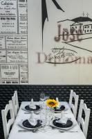 a table with white chairs and a table with glasses at Hotel Alendouro in Macedo de Cavaleiros