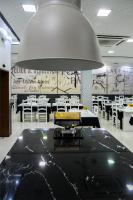 a restaurant with white tables and a large light fixture at Hotel Alendouro in Macedo de Cavaleiros