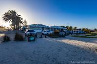 un parcheggio con auto parcheggiate di fronte a un edificio di Genoeg a Langebaan