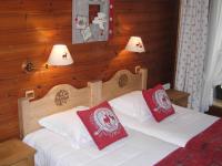 a bedroom with a bed with two red pillows at Au Bois de Lune in Châtel
