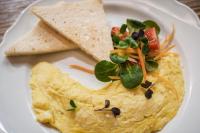 科尔蒂纳丹佩佐Casa Guargnè的一个白色盘子里装着煎蛋卷、玉米饼和沙拉。