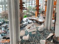 a restaurant with white chairs and tables and windows at Canal Central Hotel Business Bay in Dubai