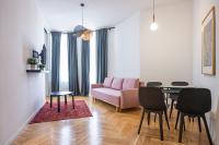 Una sala de estar con una mesa y un sofá rosa. en Zest and Nest Apartments in the center, en Zagreb