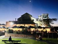 una persona sentada en un banco frente a un edificio en Budapest Boutique Hotel, en Edgemead