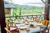 een tafel met borden eten op een balkon bij Arbuya River Hill in Ban Na Kok