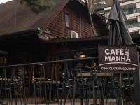 una caffetteria con tavoli e sedie di fronte a un edificio di resort comfort ad Araras Petropolis