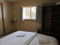 a bedroom with a large white bed with a window at Sundeck Hotel in Perisher Valley