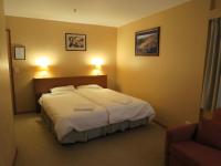 a hotel room with a bed and a chair at Sundeck Hotel in Perisher Valley