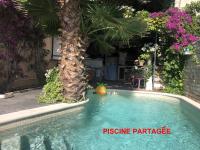 ein Swimmingpool mit einer Palme in einem Hof in der Unterkunft Les Grimaldines - Maison d&#39;Hôtes in Cagnes-sur-Mer