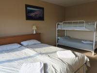 a bedroom with two beds and a bunk bed at Sundeck Hotel in Perisher Valley