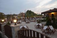 eine Gruppe von Tischen und Stühlen auf einer Terrasse in der Unterkunft Семеен хотел Звезда in Sŭdievo