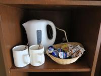 a shelf with two cups and a tea pot and a basket at Sundeck Hotel in Perisher Valley