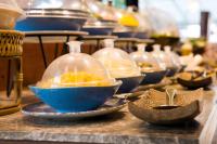 um balcão com tigelas e pratos sobre uma mesa em BJ & Radisson Sea View Hotel em Ko Yao Yai