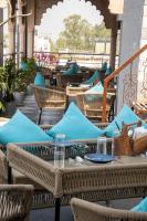 Un restaurante al aire libre con mesas y sillas azules. en Hotel Sun Grand, en Agra