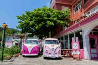 two pink and white cars parked in front of a building at Evening Sun B&amp;B in Green Island