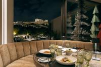 uma mesa com pratos de comida e uma árvore de Natal em Divani Palace Acropolis em Atenas