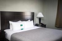 a hotel room with a bed with a book on it at Quality Inn Airport in Colorado Springs