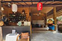 Mae Mae Home في Ban Tham: مطعم به تمثال صغير لطاهٍ في غرفة بها طاولة