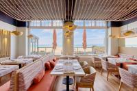 a restaurant with tables and chairs and a view of the ocean at Antinéa in Saint Malo