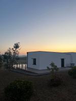 un bâtiment blanc avec un coucher de soleil en arrière-plan dans l'établissement Domaine de Chabrague, à Amou