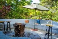 Umunthu Space & Lodge في Mzuzu: فناء مع أريكة ومظلة