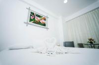 a bedroom with a white bed with a picture on the wall at Hotel Suisui in Tarapoto
