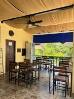 a restaurant with wooden tables and chairs and a ceiling at Sawasdee Home Stay Resort & Pool in Khao Lak