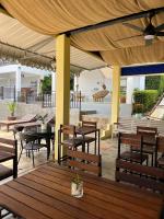an outdoor patio with wooden tables and chairs at Sawasdee Home Stay Resort & Pool in Khao Lak