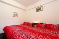 a red bed with red pillows in a bedroom at Fangyi Homestay in Ji&#39;an