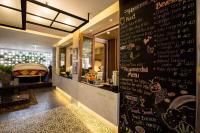 um restaurante com uma parede preta com escrita nele em Ploen Chaweng by Tolani em Chaweng