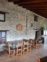 リベス・デ・フレセルにあるCal Tonico Ruralのテーブルと椅子と時計が置かれた石の壁