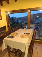 リベス・デ・フレセルにあるCal Tonico Ruralのダイニングテーブル(白いテーブルクロス付)、窓