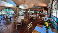 een restaurant met tafels en stoelen en mensen op de achtergrond bij Hotel Mendihuaca by On vacation in Santa Marta