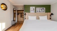 Un dormitorio con una cama grande y una pared verde. en Campanile NATURE - Meaux, en Meaux