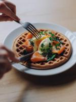 東京にあるHotel K5のフォークとナイフを使ってワッフルの皿を食べている人