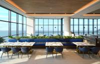 Un restaurante con mesas y sillas y grandes ventanales. en MATIE Osiria, en Busan