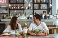 een man en vrouw aan een tafel in een restaurant bij EBS Hostel Phuket in Karon Beach