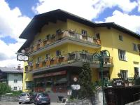 Un edificio amarillo con coches aparcados delante. en Annaberger Musikantenwirt, en Annaberg im Lammertal