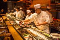 un grupo de chefs que preparan comida en una cocina en Hotel Crescent Court, en Dallas