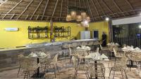 um restaurante com mesas, cadeiras e um bar em Hotel Wayira Beach by On vacation em Ríohacha