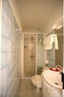 a bathroom with a shower and a toilet and a sink at Hôtel Du Soleil in Saint-Raphaël