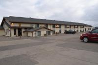 Un edificio con un coche aparcado en un estacionamiento. en Super 8 by Wyndham Devils Lake, en Devils Lake