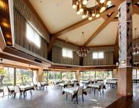 uma sala de jantar com mesas e cadeiras e um lustre em Izu-Kogen Wan Wan Paradise Hotel & Cottage em Ito