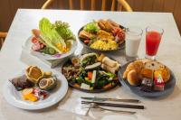 Una mesa con cuatro platos de comida y bebidas encima. en HOTEL PIN Jiaoxi, en Jiaoxi