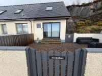 una casa con una valla delante en An Bothan, en Mallaig