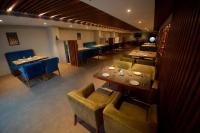 ein Restaurant mit Tischen und Stühlen in einem Raum in der Unterkunft Ambal Regency in Pudukād